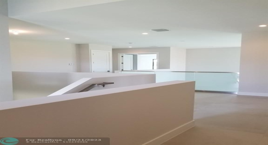 Photo from previously built Deerwood Model Home.  Upstairs hallway with optional glass railing