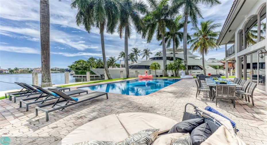 Outdoor waterfront Point Lot with pool area with outdoor dining, lounge chairs, BBQ & siting area.
