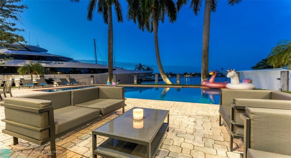 Outdoor waterfront Point Lot with pool area with outdoor dining, lounge chairs, BBQ & siting area.