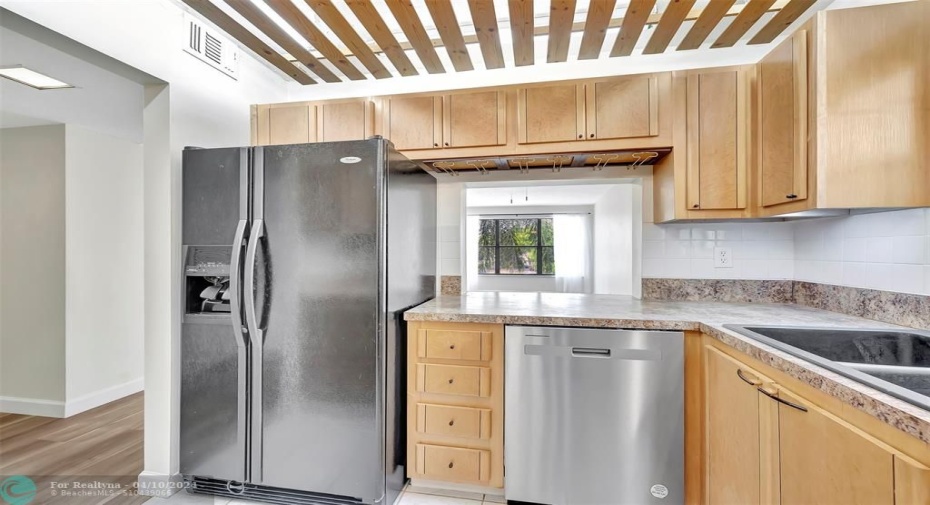 YOUR FUTURE Kitchen has SIDE-BY-SIDE REFRIGERATOR WITH WATER & ICE DISPENSER, CUSTOM CABINETS (EXOTIC BURL VANEER), CUSTOM WOOD SLATTED CEILING, NEW DISHWASHER, Lots of Cabinet and Counter Space, a Pass-thru window to the Dining Area, and even comes complete with MOTION SENSOR UNDER CABINET LIGHTING & UNDER CABINET CAN OPENER & More! Great for Entertaining!