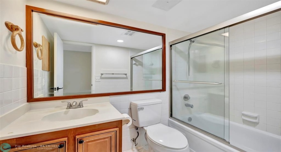 GUEST BATHROOM Includes CUSTOM CABINETS (EXOTIC BURL VANEER), CUSTOM MIRROR (EXOTIC BURL VANEER), BRAND NEW TALL TOILET, GLASS ENCLOSED TUB/SHOWER COMBO and more than enough room for your Guests and while Entertaining.