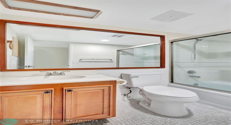 GUEST BATHROOM Includes CUSTOM CABINETS (EXOTIC BURL VANEER), CUSTOM MIRROR (EXOTIC BURL VANEER), BRAND NEW TALL TOILET, GLASS ENCLOSED TUB/SHOWER COMBO and more than enough room for your Guests and while Entertaining.