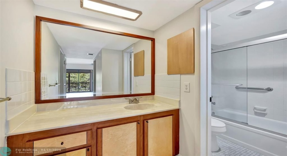 Primary En-Suite Bathroom Includes CUSTOM CABINETS (EXOTIC BURL VANEER), CUSTOM MIRROR (EXOTIC BURL VANEER), BRAND NEW TALL TOILET, GLASS ENCLOSED TUB/SHOWER COMBO, SEPARATE Room/Door for Bath & toilet for Privacy and more than enough cabinet space as well as a Linen Closet in your Primary Bedroom.
