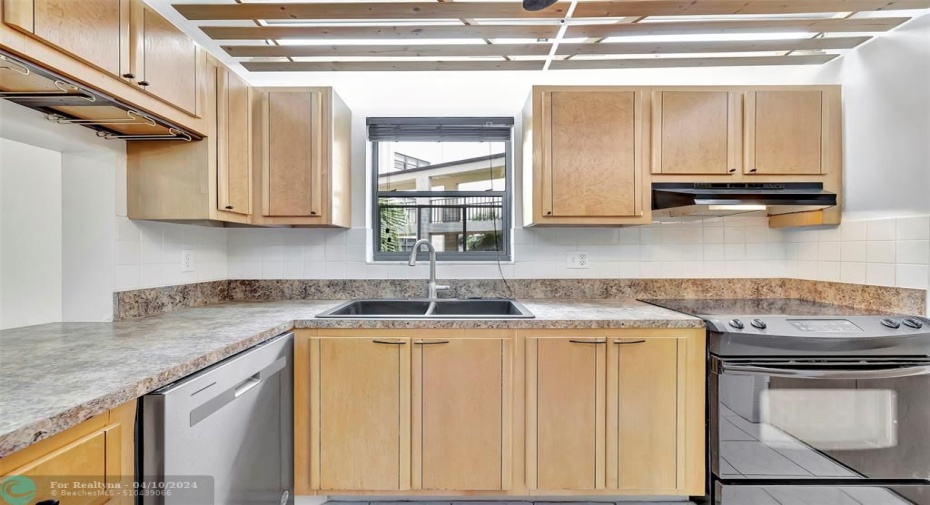 Once inside you will see a Bright, Spacious, Fabulous Kitchen With CUSTOM CABINETS (EXOTIC BURL VANEER), CUSTOM WOOD SLATTED CEILING, NEW DISHWASHER, Lots of Cabinet and Counter Space, a Pass-thru window to the Dining Area, and even comes complete with MOTION SENSOR UNDER CABINET LIGHTING. SIDE-BY-SIDE REFRIGERATOR WITH WATER & ICE DISPENSER & MORE!