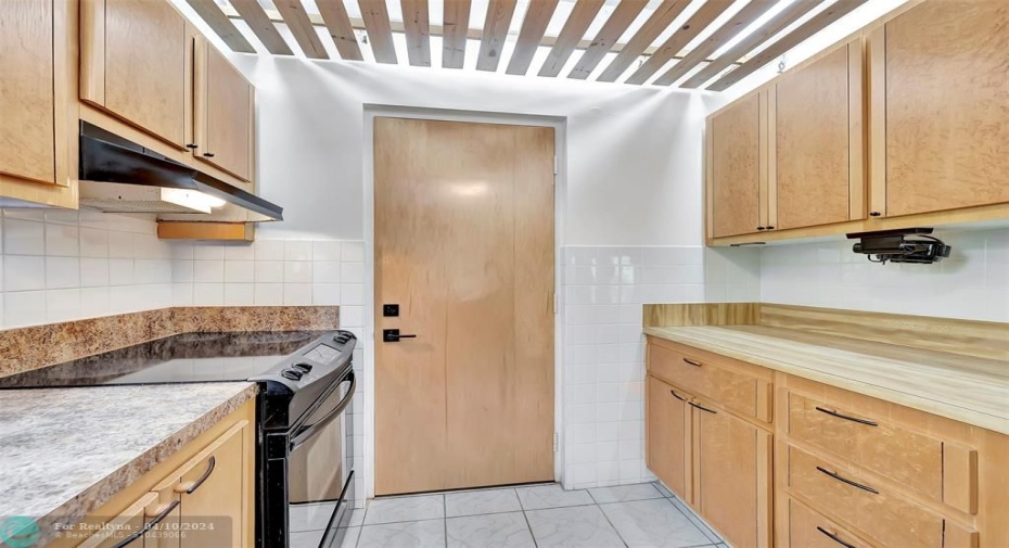 2nd EXIT Door in your FUTURE Fabulous Kitchen With CUSTOM CABINETS (EXOTIC BURL VANEER), CUSTOM WOOD SLATTED CEILING, NEW DISHWASHER, Lots of Cabinet and Counter Space, a Pass-thru window to the Dining Area, and even comes complete with MOTION SENSOR UNDER CABINET LIGHTING. SIDE-BY-SIDE REFRIGERATOR WITH WATER & ICE DISPENSER & MORE!