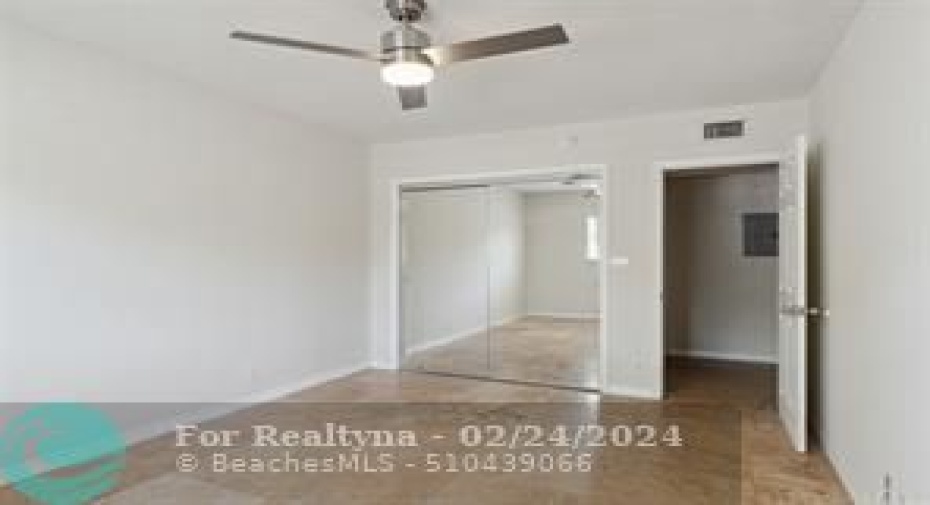 First bed showing closet door and ceiling fan