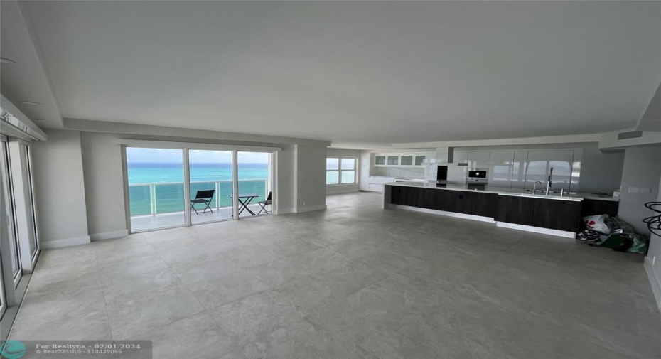 The kitchen is stream-lined and open. The kitchen island contrasts beautifully with the white floor-to-ceiling white cabinets.