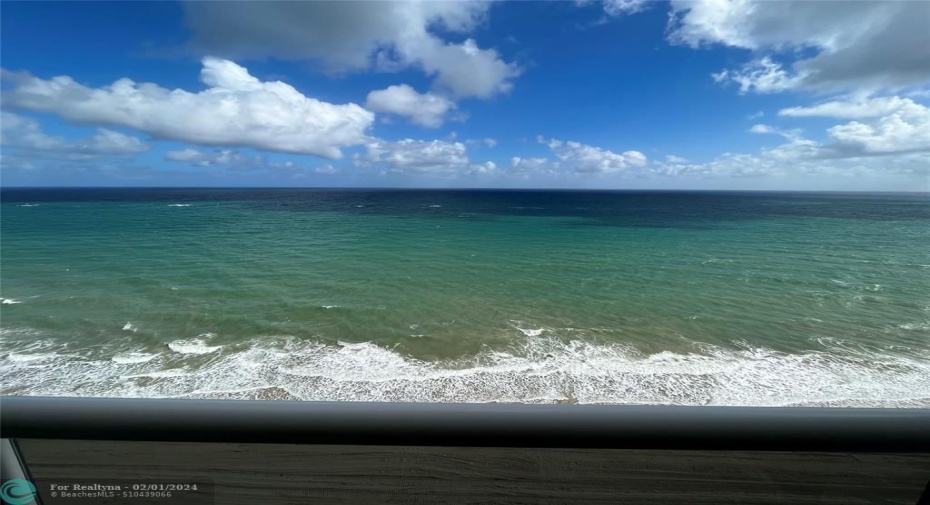 Unobstructed direct view of the ocean showing the glass balcony railing.