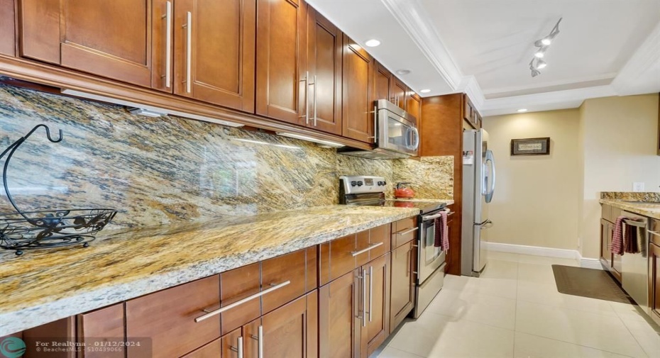 Upscale designer kitchen with exquisite granite countertops and backsplash.    Stainless steel appliances, Maytag refrigeration and stove