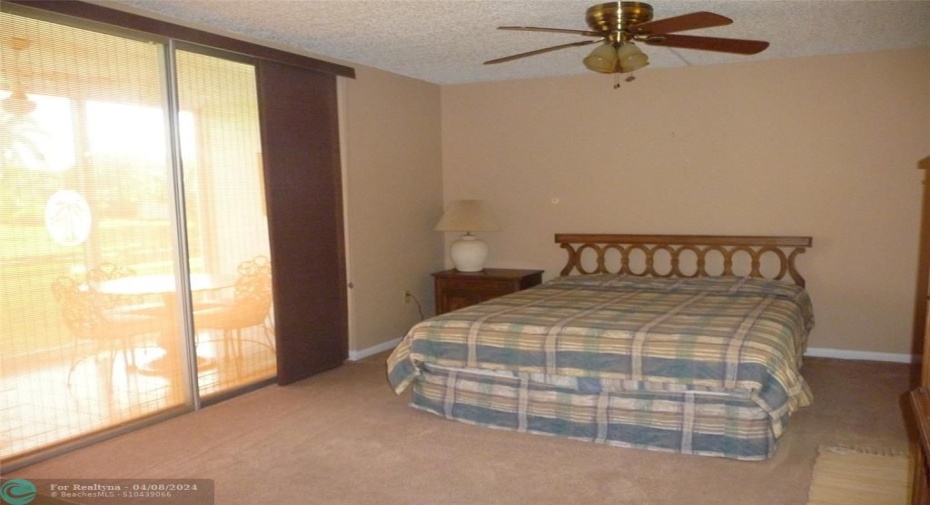 MAIN BEDROOM;SLIDING GLASS DOORS TO ENCLOSED PATIO