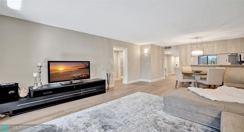 Open Living Area has a fresh coat of paint, new floors with designer style baseboards, and new modern lighting fixtures.