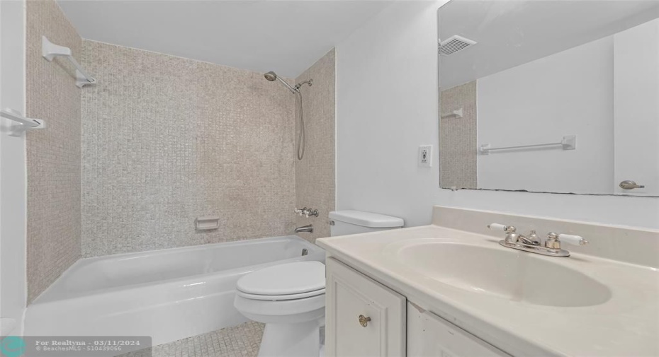 Master bathroom with tub/shower combo and white counters and cabinets