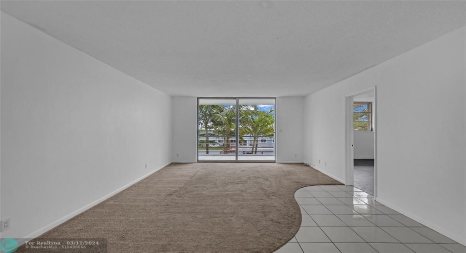 Spacious living room with carpet flooring and water views