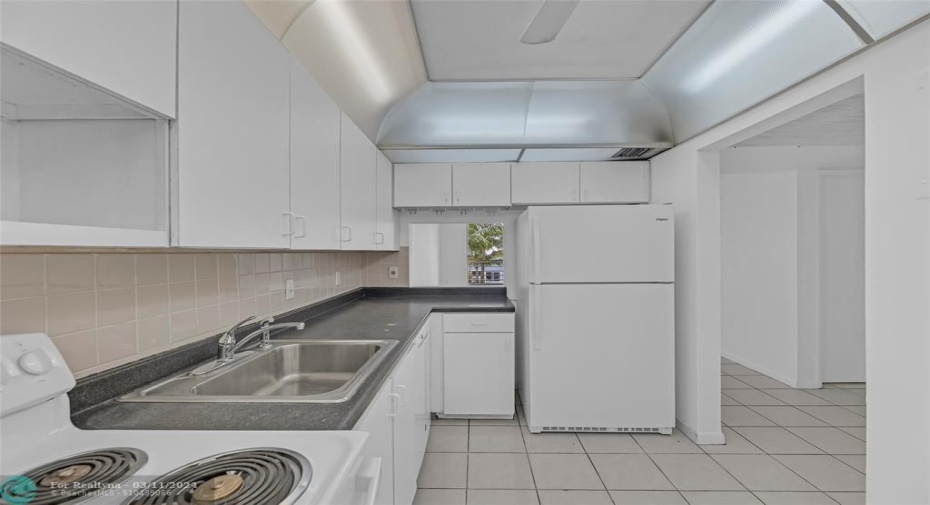 Kitchen offers great cabinet space and pass through window into dining room