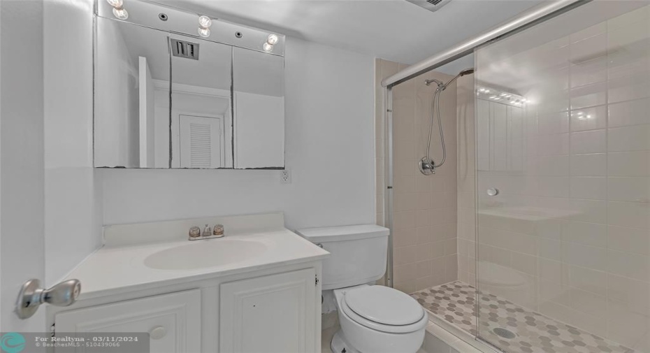 Walk in shower offered in guest bedroom with white cabinets