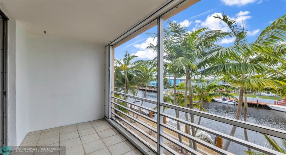 Spacious screened patio with water and tropical landscaping views
