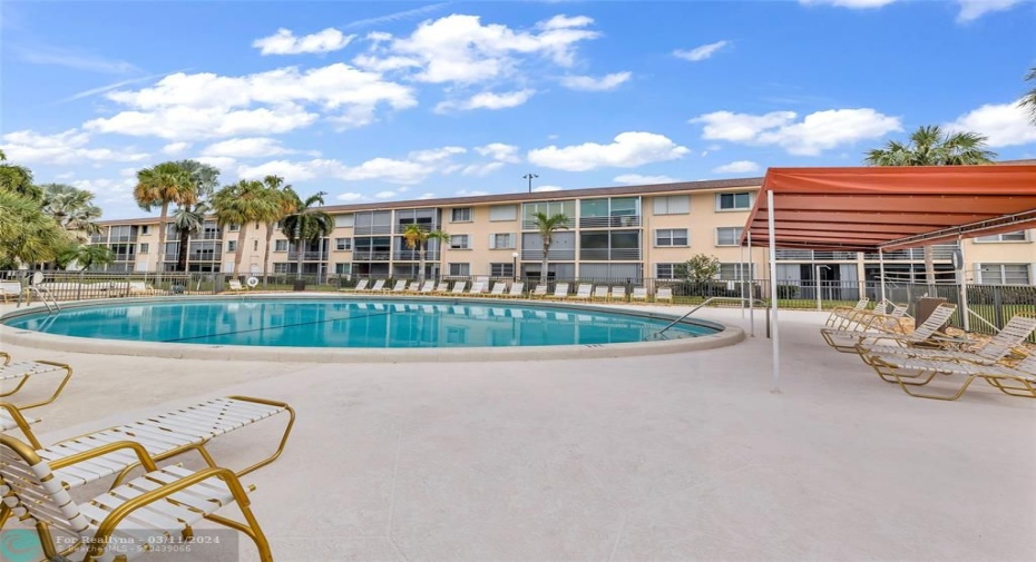 Spacious pool deck offers covered and uncovered lounge chairs