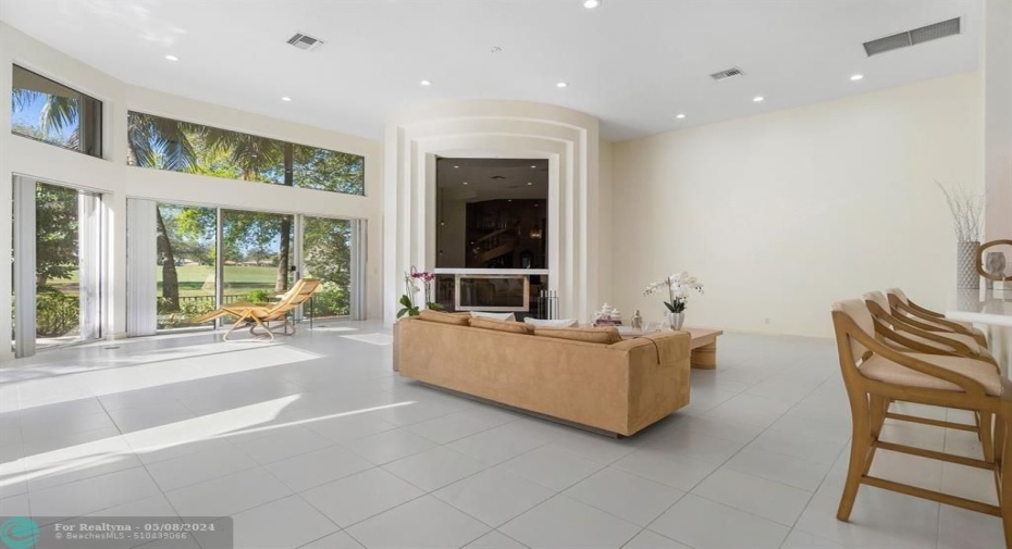 Grande family room with floor to ceiling fireplace and abundant windows!