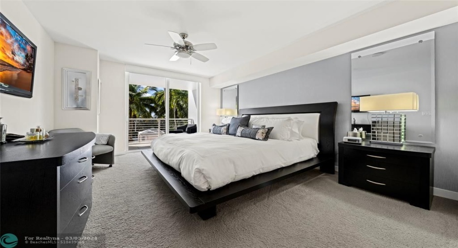 Spacious primary bedroom with balcony access, his and her walk-in closets along with dual linen/whatever closets