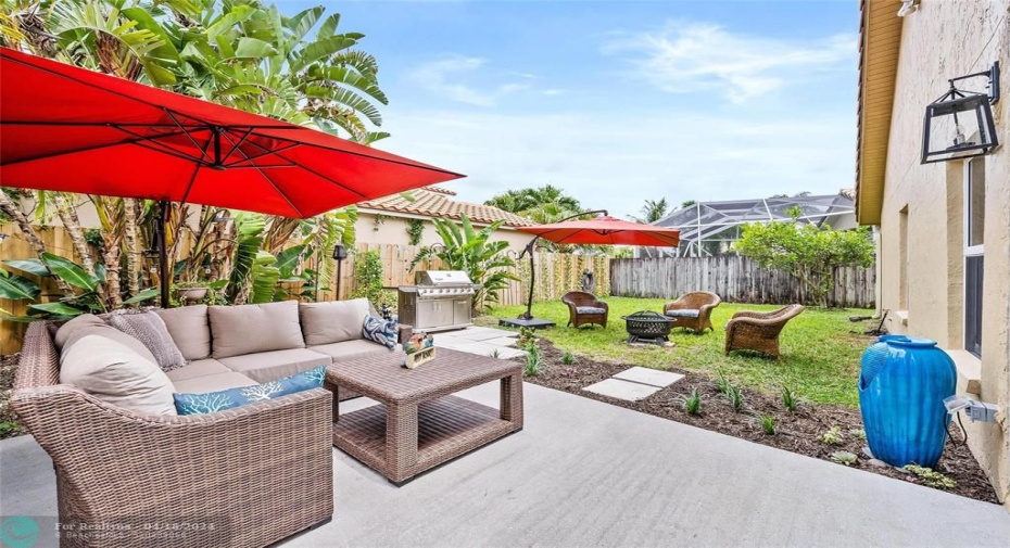 patio with seating, bbq grill and fenced in yard.