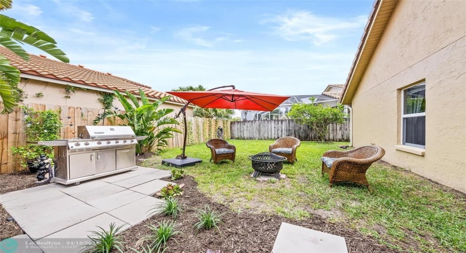 patio with seating, bbq grill and fenced in yard.
