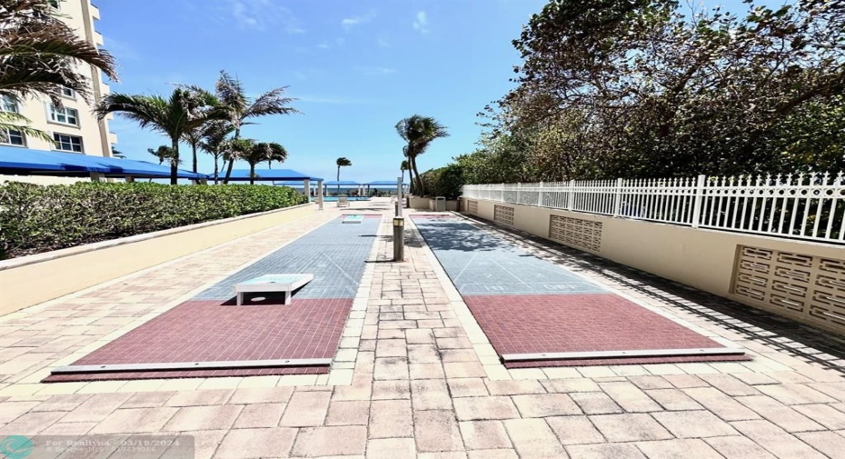 Pool area with shuffle board and corn hole