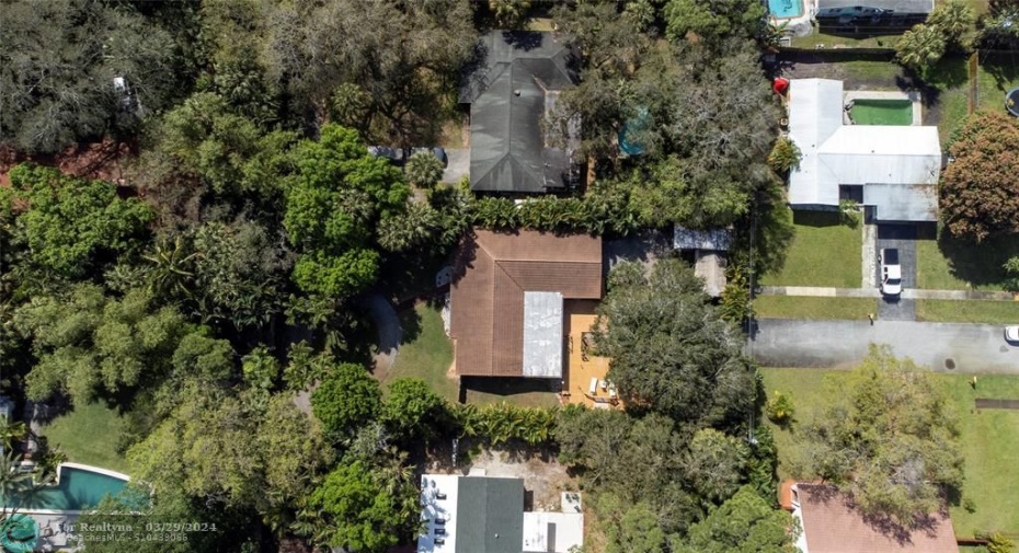 top of house shows front wooded area and separate street access in back