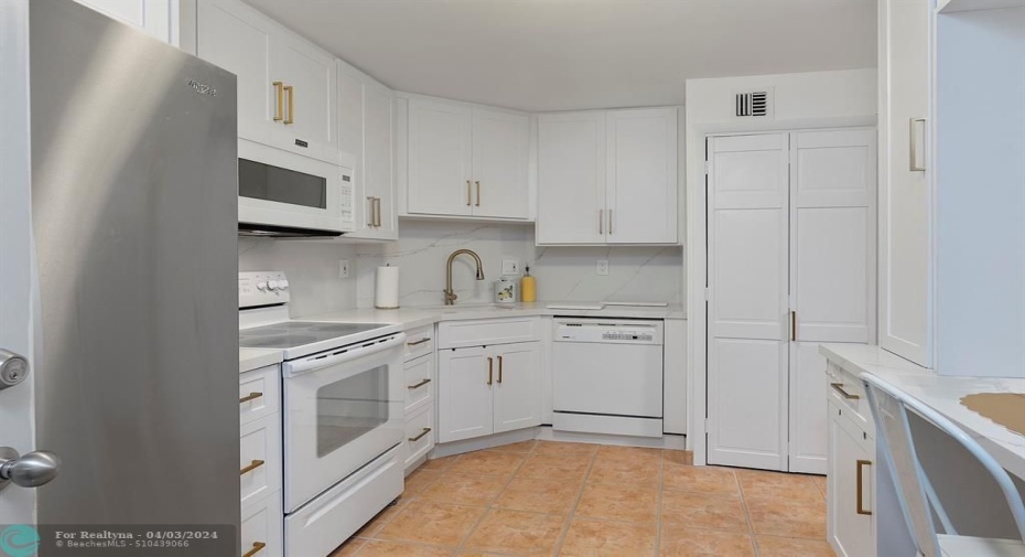 Full Size Stackable Washer & Dryer in Kitchen behind the white bifold door