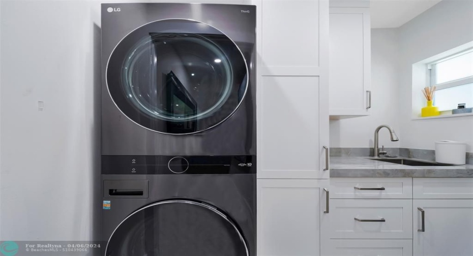 Full laundry room with new LG washer & dryer, cabinets with extra storage and laundry sink.