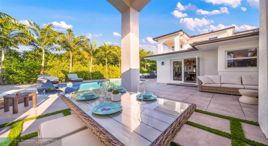 Covered outdoor dining area with sitting area to the side.