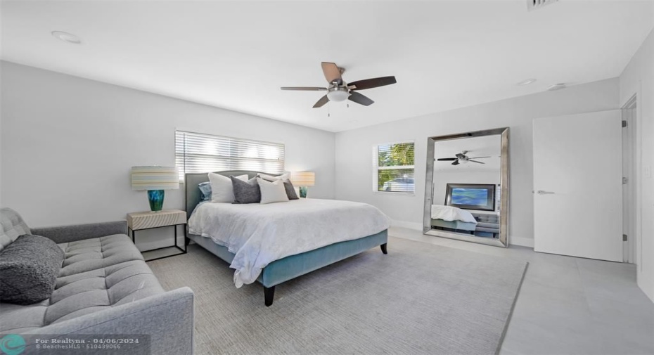 bedroom #3 with queen size bed, sofa and full length mirror.