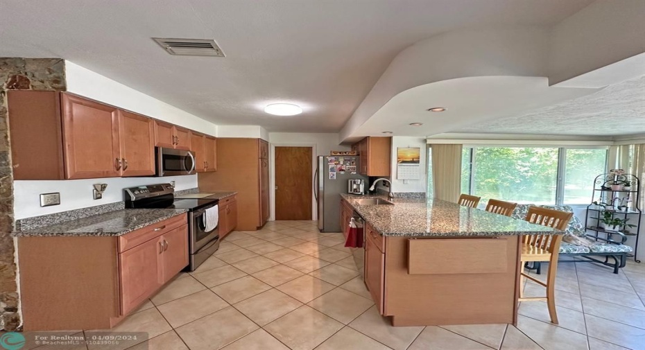 Updated kitchen with wood cabinets and granite countertops.
