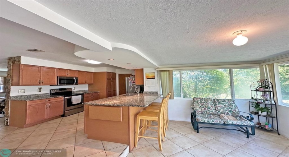 Updated kitchen with wood cabinets and granite countertops.