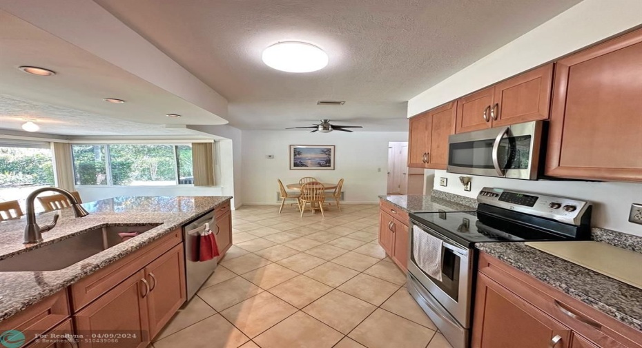 Updated kitchen with wood cabinets and granite countertops.