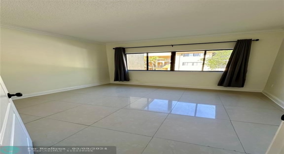 spacious guest bedroom features an oversized window for an abundance of natural light