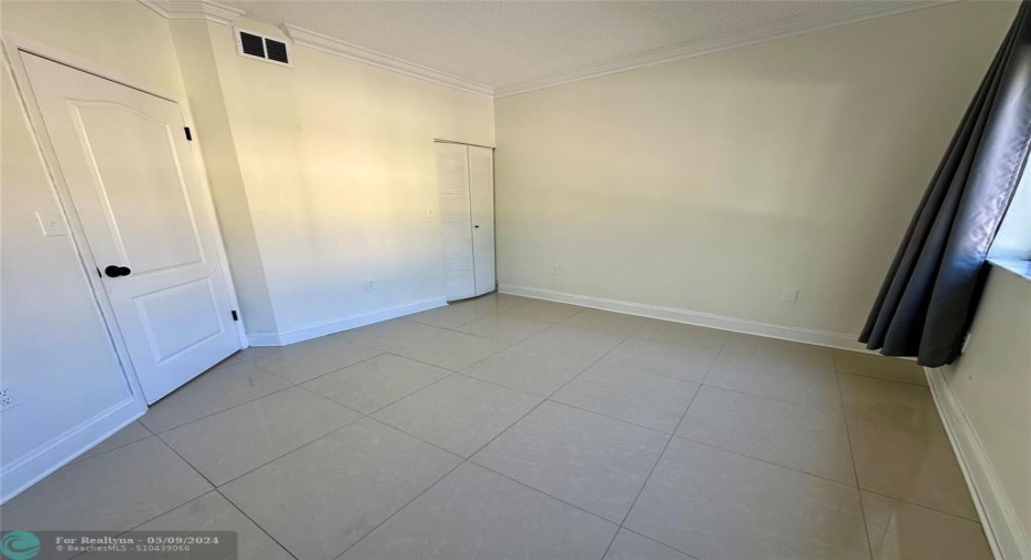 guest featuring a walk-in closet , crown molding & upgraded baseboards