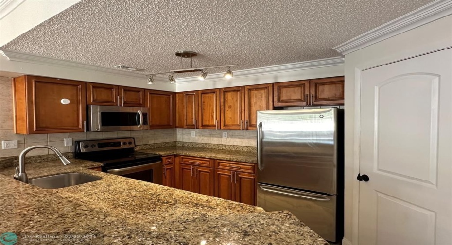 Spacious cooking space featuring crown molding , new light fixture and faucet