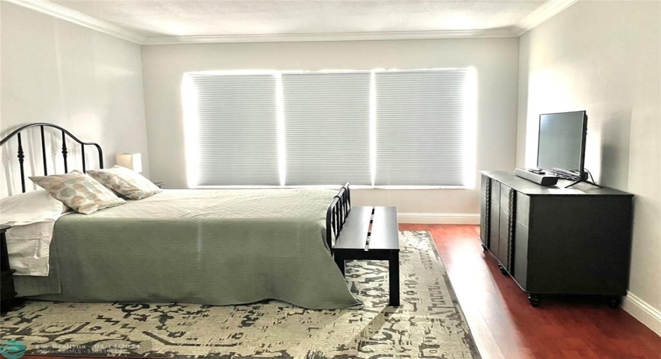 very large, light, bright primary bedroom overlooking beautiful golf course with lots of greenery