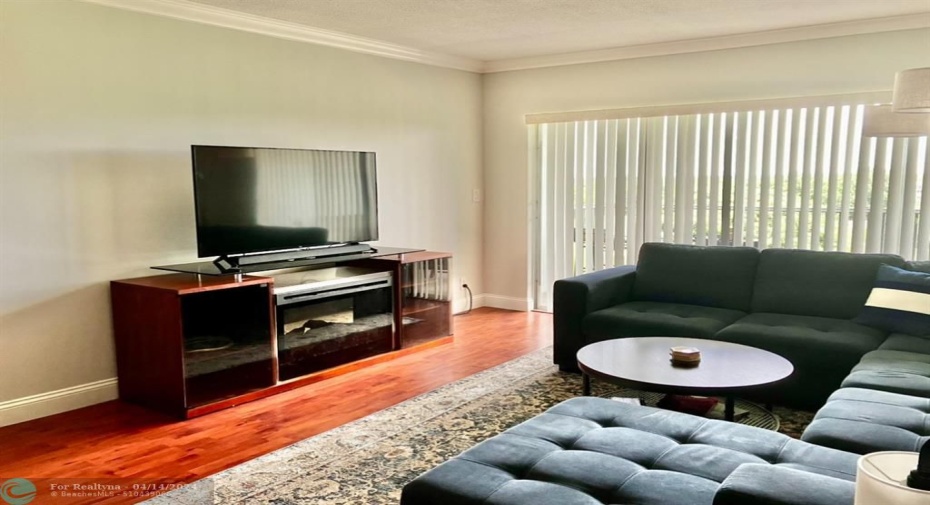 living room with electric fireplace and sliding glass doors to screened in porch overlooking golf course