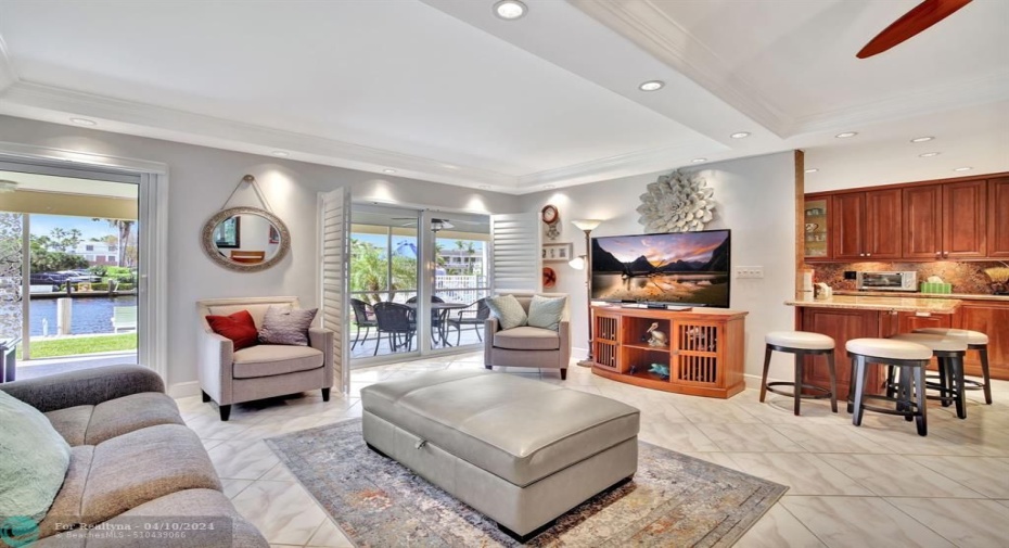 The open living/dining area has an abundance of natural light showcasing the views from the screened in patio off the front.