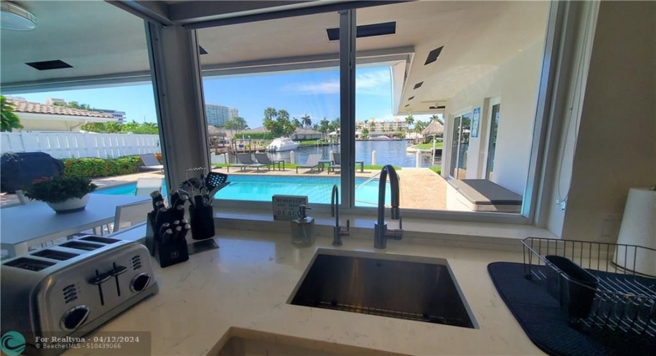 what a view from your kitchen overlooking the pool and water and yachts gliding by
