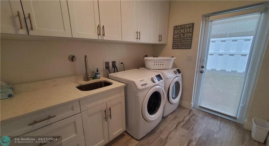 laundry sink and plenty of storage and cabinet space