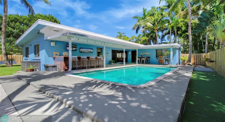 Outdoor living with pool, custom bar, covered patio, putting green, sun deck and room for fire pit too!
