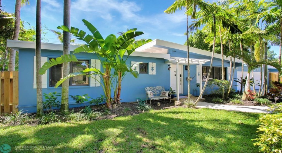 Tropical landscaped home with attractive entry, spacious concrete driveway for parking and gated, fenced property!