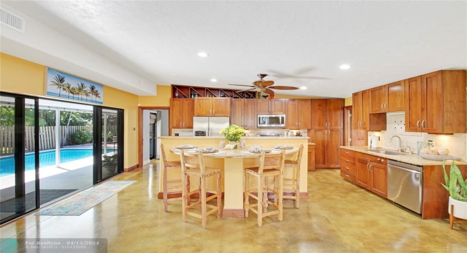 Custom hardwood cabintry, stainless appliances, breakfast bar island, opens to pool and split fllor plan to guest and third bedroom area.