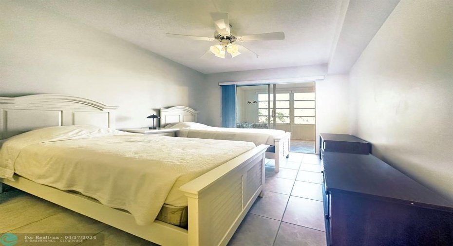 Guest Bedroom has Sliding Doors to Enclosed Patio