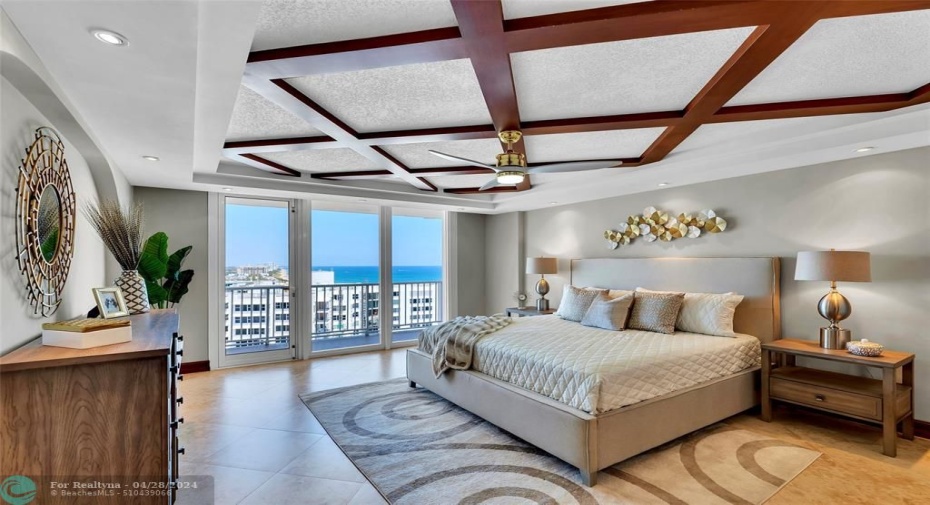 Primary bedroom features a uniquely designed double tray ceiling with rich wood beams and recessed lighting