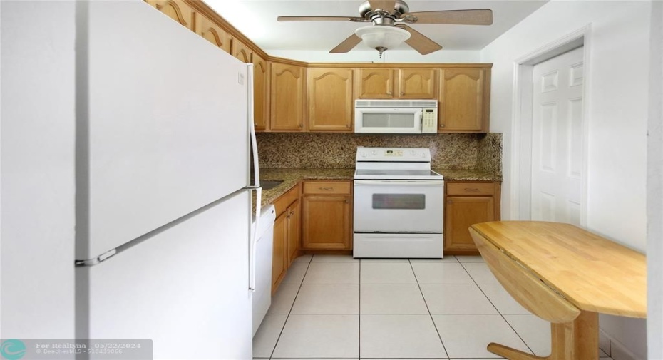 updated kitchen with ceiling fan and service entrance door.