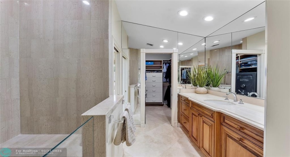 WALK IN MARBLED STEP DOWN SHOWER WITH DOUBLE SHOWER HEADS AND FAUCETS AND SEATING AREA