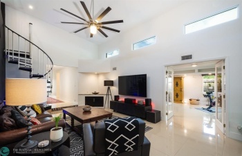 living room with spiral stairs to the loft